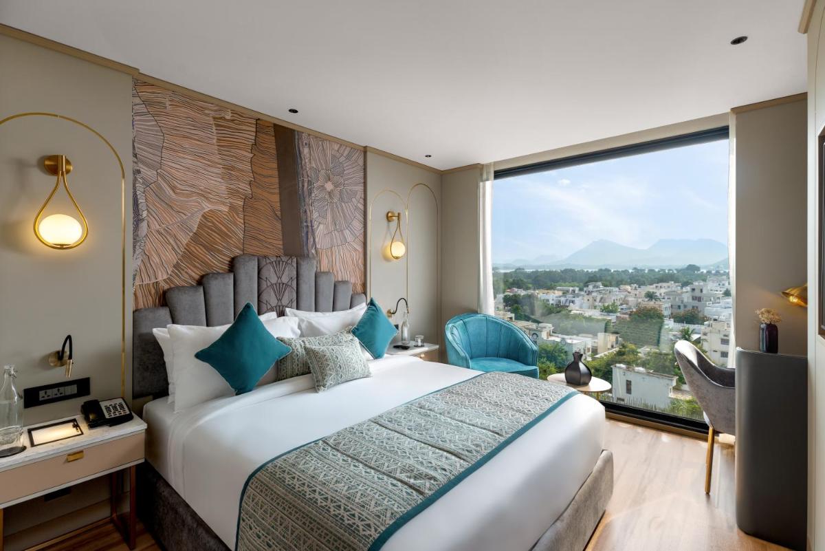a bedroom with a large bed and a large window at Parallel Hotel Udaipur, a member of Radisson Individuals in Udaipur