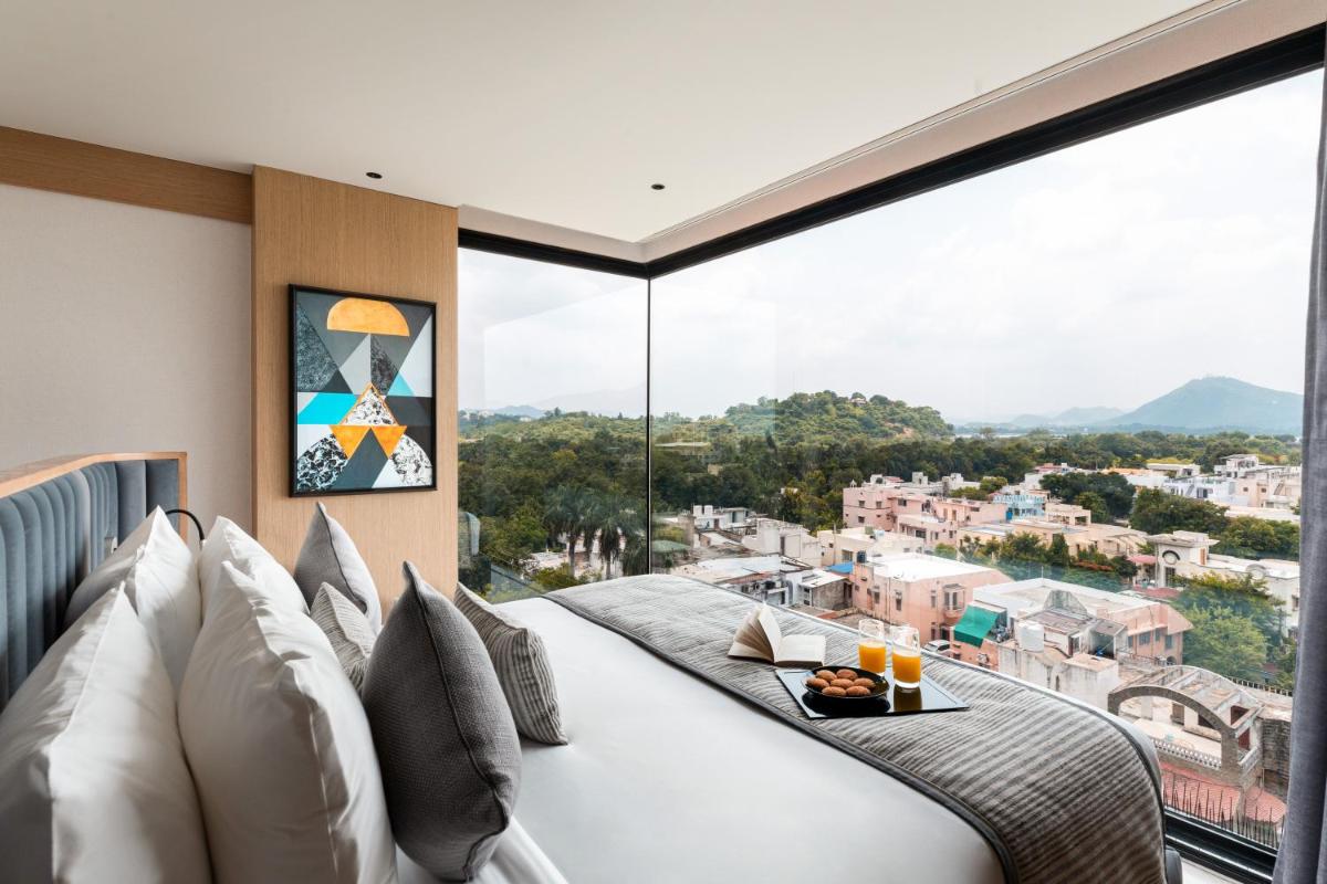 a bedroom with a bed and a large window at Parallel Hotel Udaipur, a member of Radisson Individuals in Udaipur