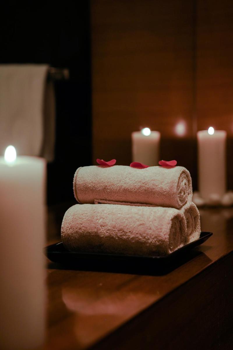 three towels on a table next to candles at Crowne Plaza Today Gurugram by IHG in Gurgaon
