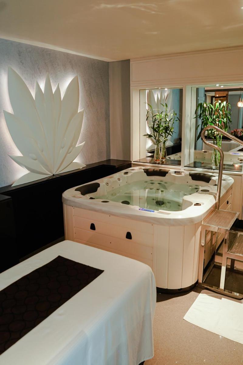 a jacuzzi tub in a room with a flower on the wall at Crowne Plaza Today Gurugram by IHG in Gurgaon
