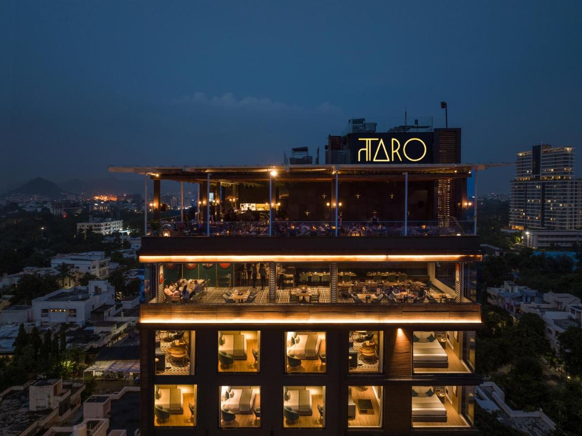 a building with a restaurant on top of it at night at Parallel Hotel Udaipur, a member of Radisson Individuals in Udaipur