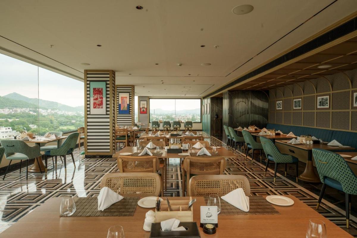 a restaurant with tables and chairs and a view at Parallel Hotel Udaipur, a member of Radisson Individuals in Udaipur