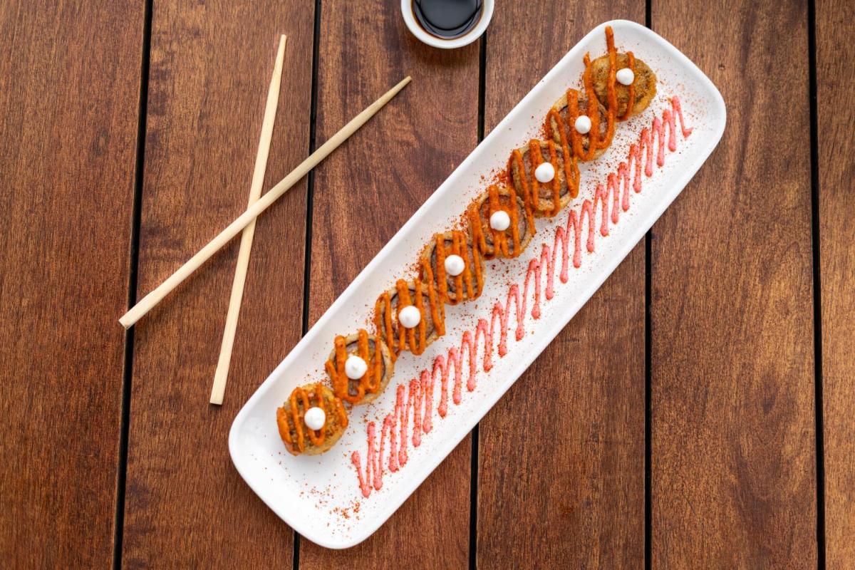 a plate of food on a wooden table with chopsticks at Parallel Hotel Udaipur, a member of Radisson Individuals in Udaipur