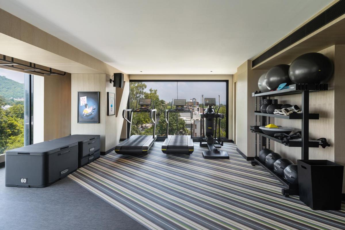 a fitness room with treadmills and a gym at Parallel Hotel Udaipur, a member of Radisson Individuals in Udaipur