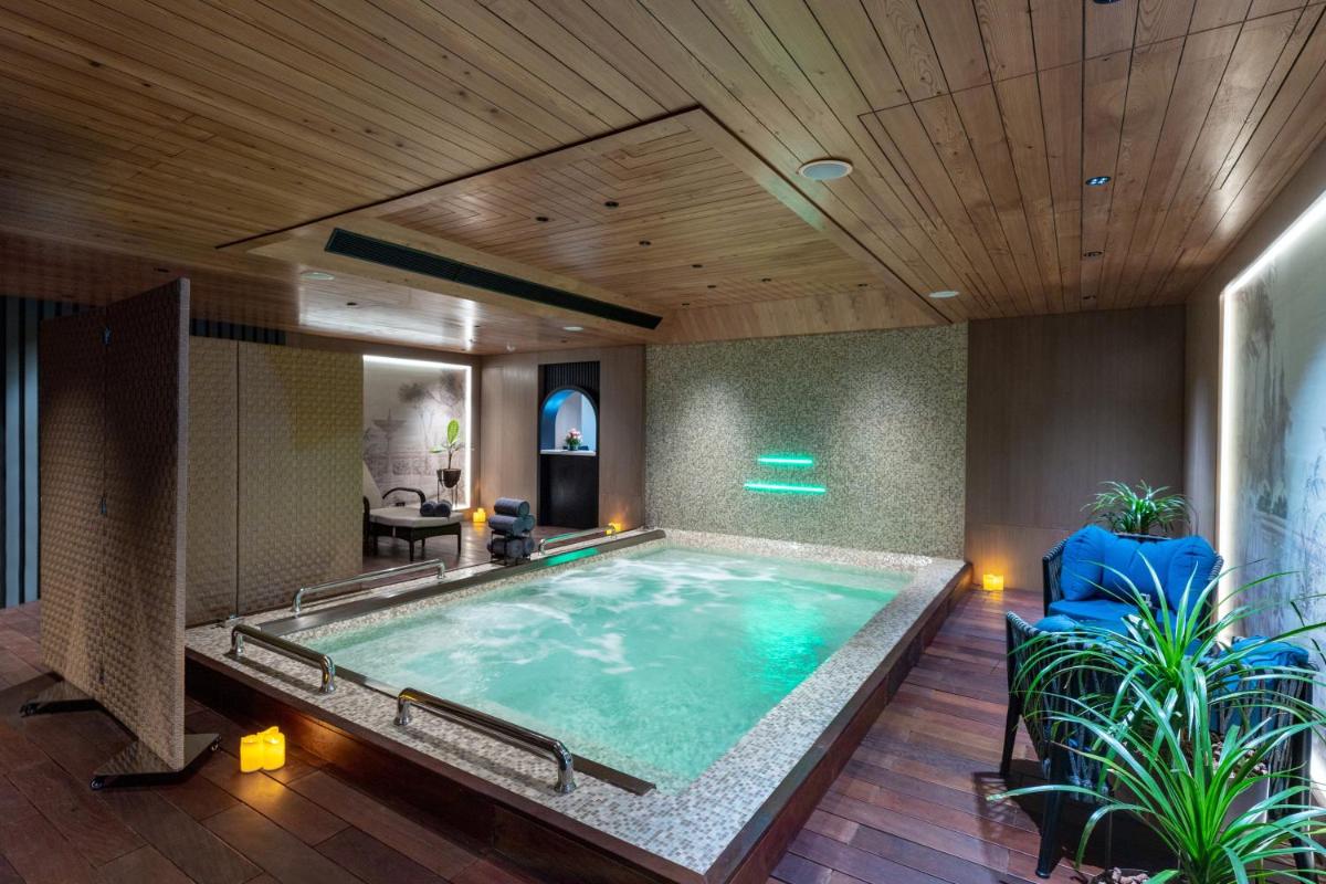 a large swimming pool in a room with a wooden ceiling at Parallel Hotel Udaipur, a member of Radisson Individuals in Udaipur