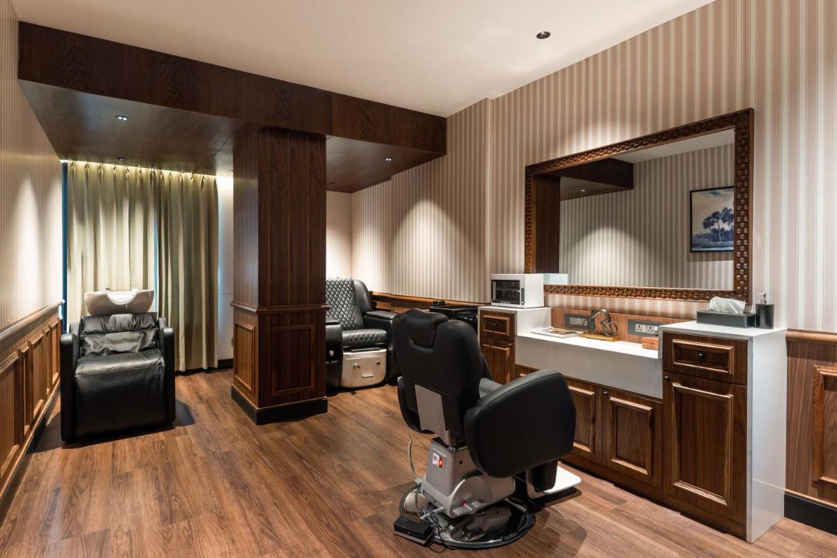 a hair salon with a mirror and a barber chair at Parallel Hotel Udaipur, a member of Radisson Individuals in Udaipur