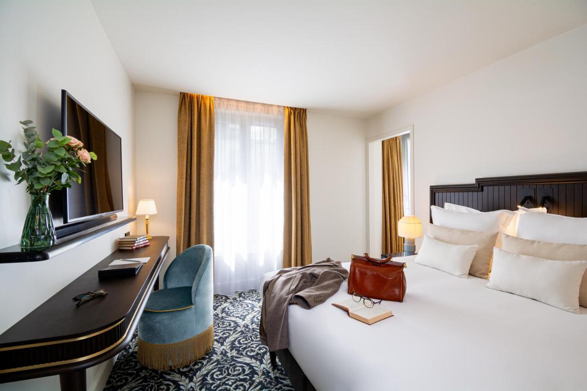 une chambre d'hôtel avec un lit et un bureau avec un ordinateur dans l'établissement Hôtel & SPA Napoléon, à Fontainebleau