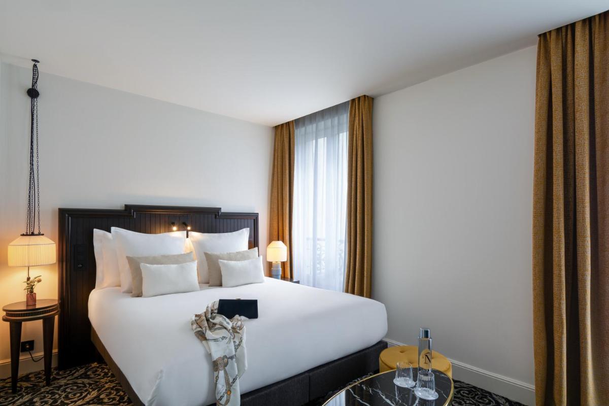 Un ou plusieurs lits dans un hébergement de l'établissement Hôtel & SPA Napoléon