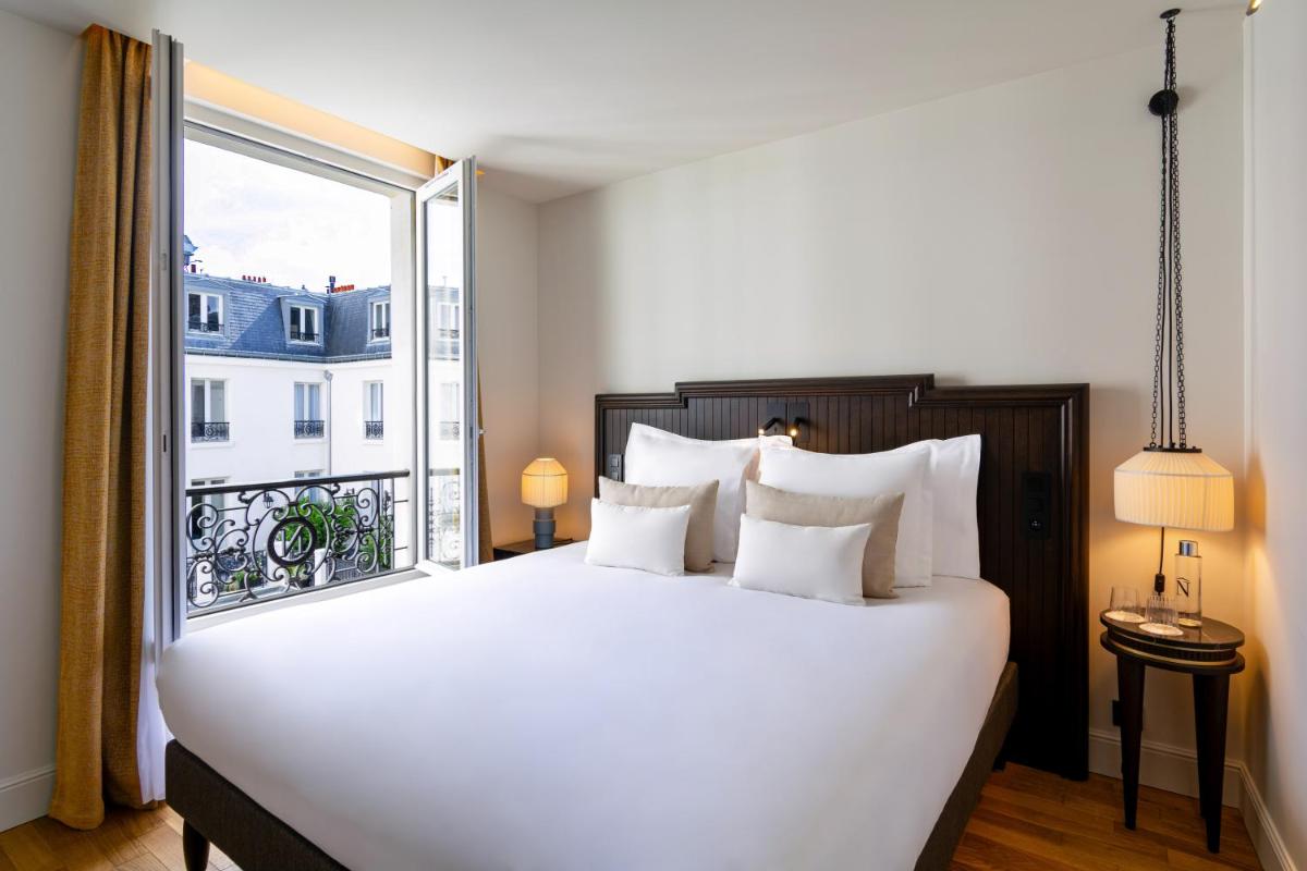 une chambre avec un grand lit avec une grande fenêtre dans l'établissement Hôtel & SPA Napoléon, à Fontainebleau 99 autres photos