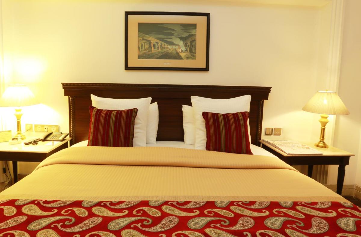 a bedroom with a large bed with two tables and two lamps at The Ashok, New Delhi in New Delhi a bedroom with a large bed with two tables and two lamps at The Ashok, New Delhi in New Delhi