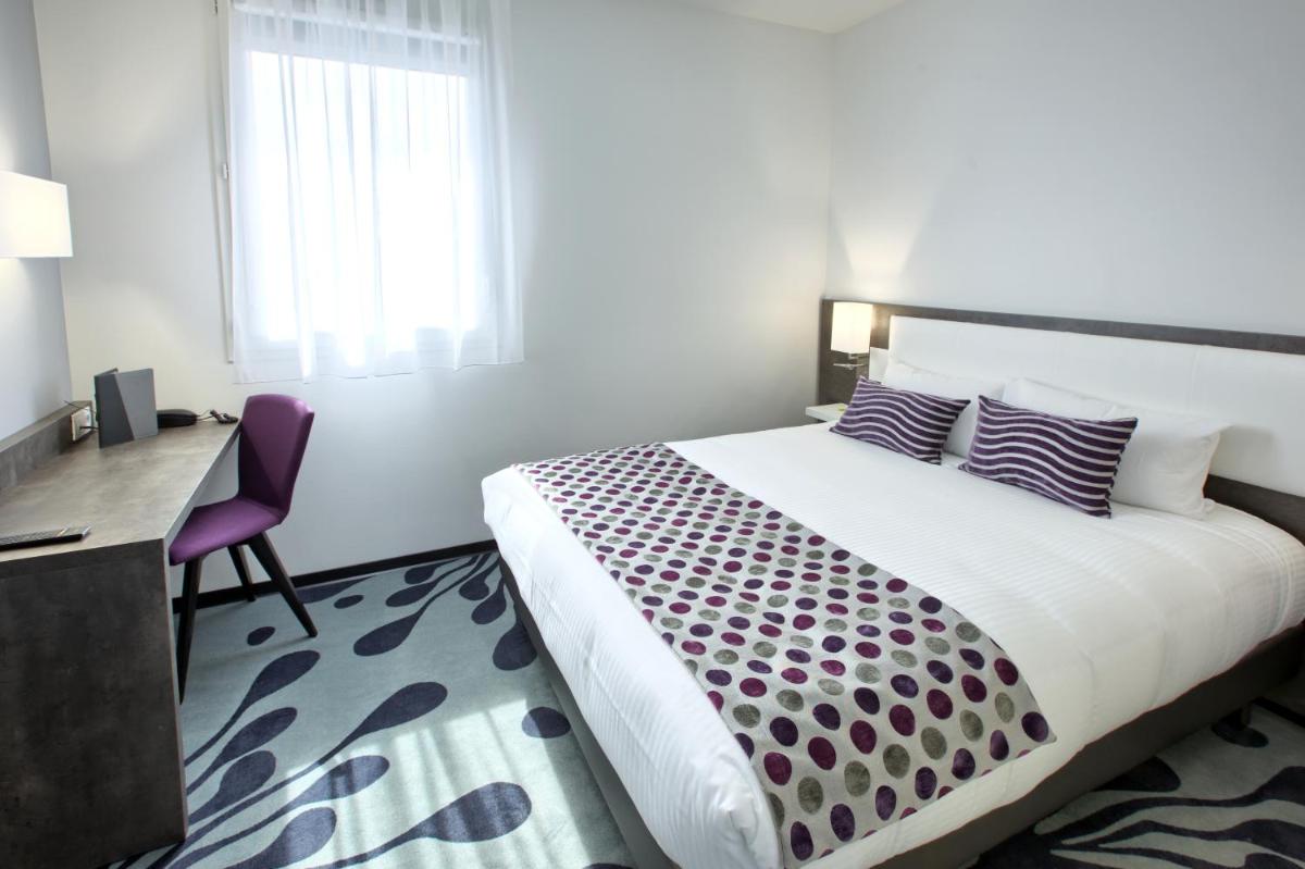 une chambre avec un lit, un bureau et une fenêtre dans l'établissement Logis Hotel Restaurant & SPA Au Comte d'Ornon, à Gradignan