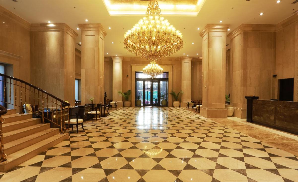 a large lobby with a chandelier and a staircase at The Ashok, New Delhi in New Delhi a large lobby with a chandelier and a staircase at The Ashok, New Delhi in New Delhi