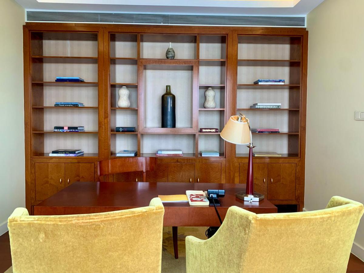 a dining room with a table and chairs and a bottle of wine at Four Seasons Hotel Mumbai in Mumbai