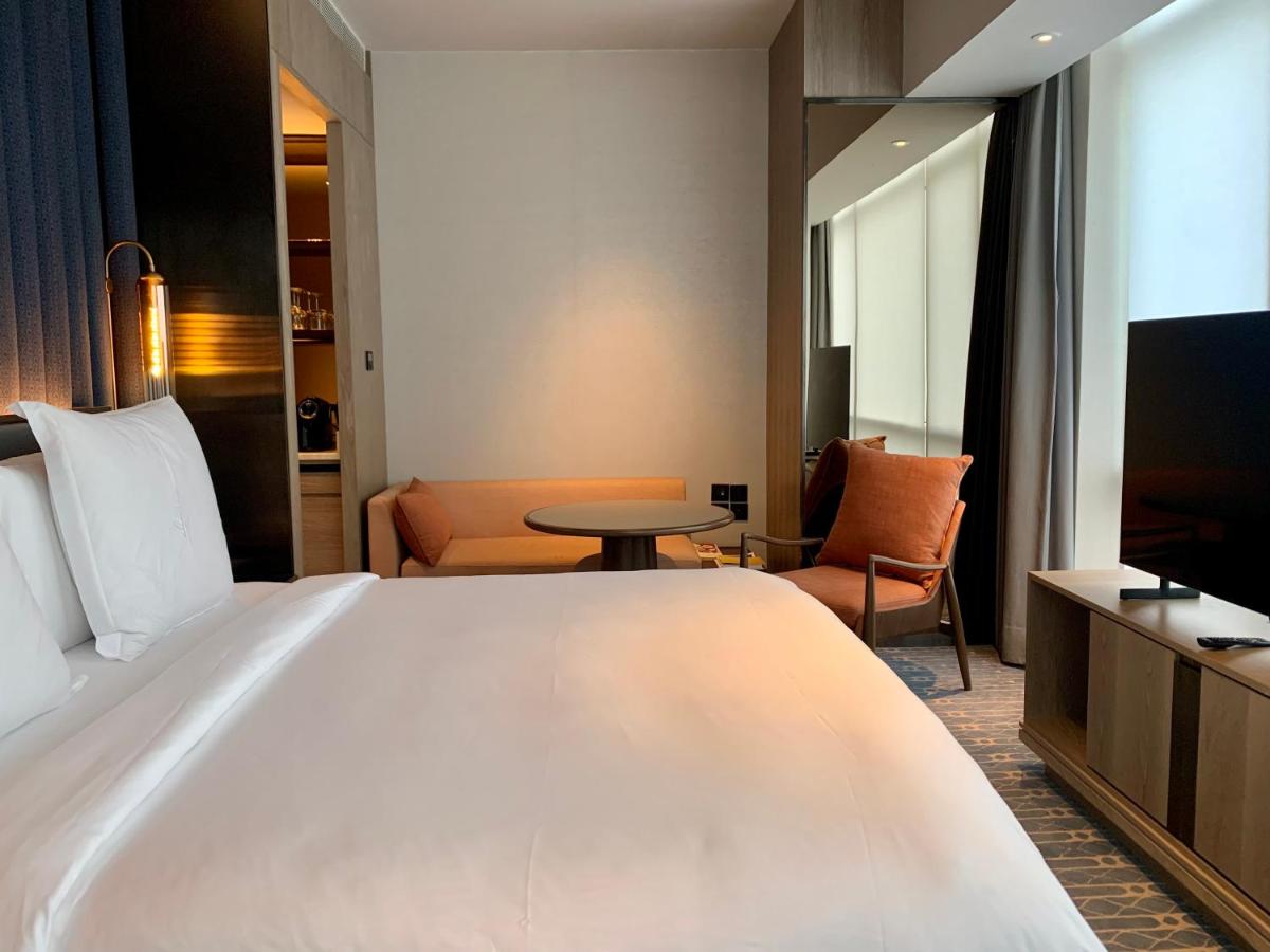 a hotel room with a large bed and a tv at Four Seasons Hotel Mumbai in Mumbai