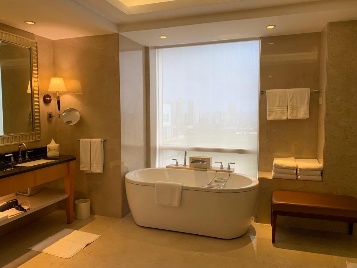 a bathroom with a bath tub and a window at Four Seasons Hotel Mumbai in Mumbai