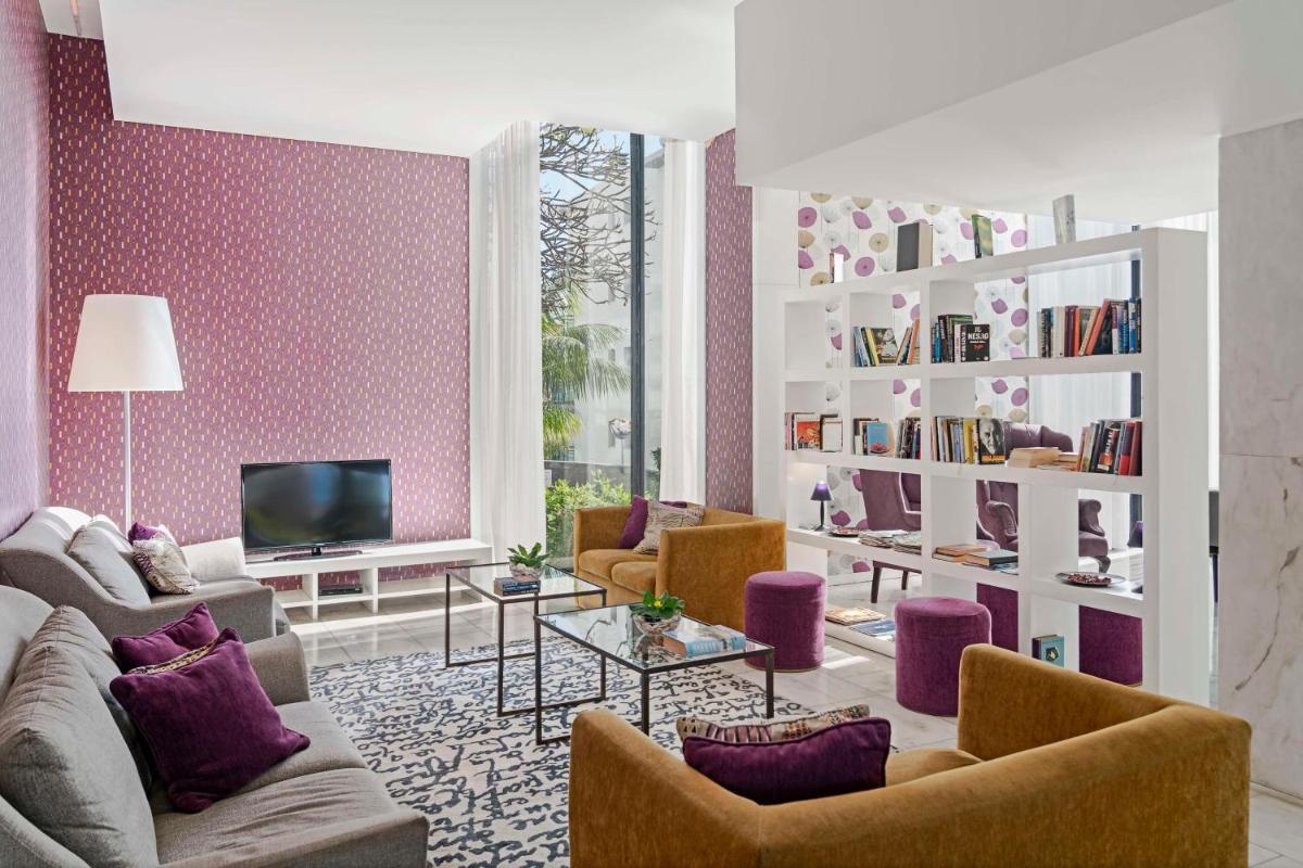 uma sala de estar com móveis roxos e uma TV em Dorisol Mimosa Studio Hotel no Funchal