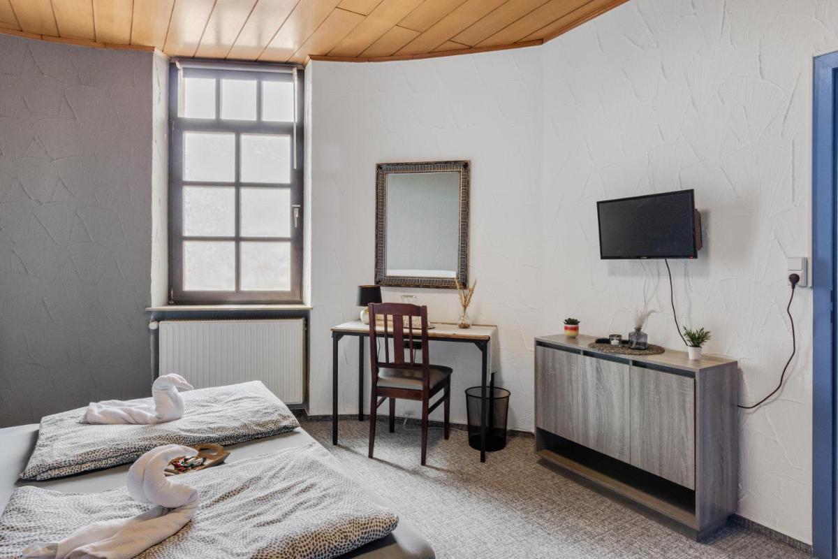 Schlafzimmer mit einem Bett, einem Spiegel und einem Schreibtisch in der Unterkunft Family and Friends Hassloch in Haßloch