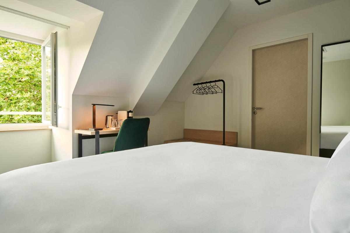 Un ou plusieurs lits dans un hébergement de l'établissement Le Grand Hôtel, The Originals Relais