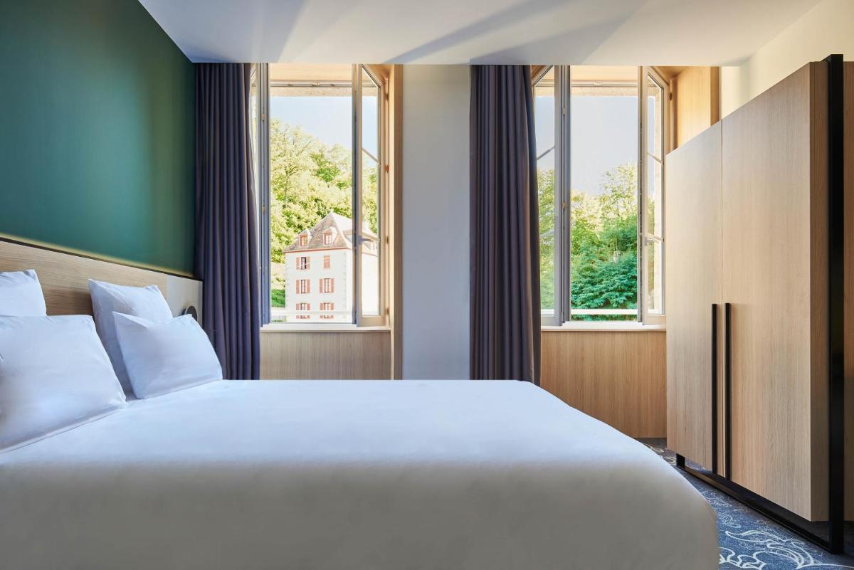 Un ou plusieurs lits dans un hébergement de l'établissement Le Grand Hôtel, The Originals Relais