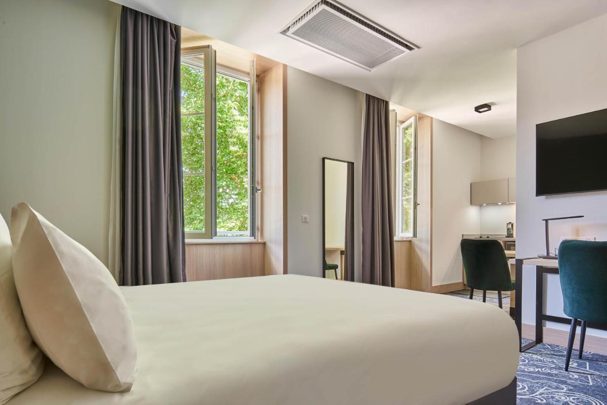 Un ou plusieurs lits dans un hébergement de l'établissement Le Grand Hôtel, The Originals Relais