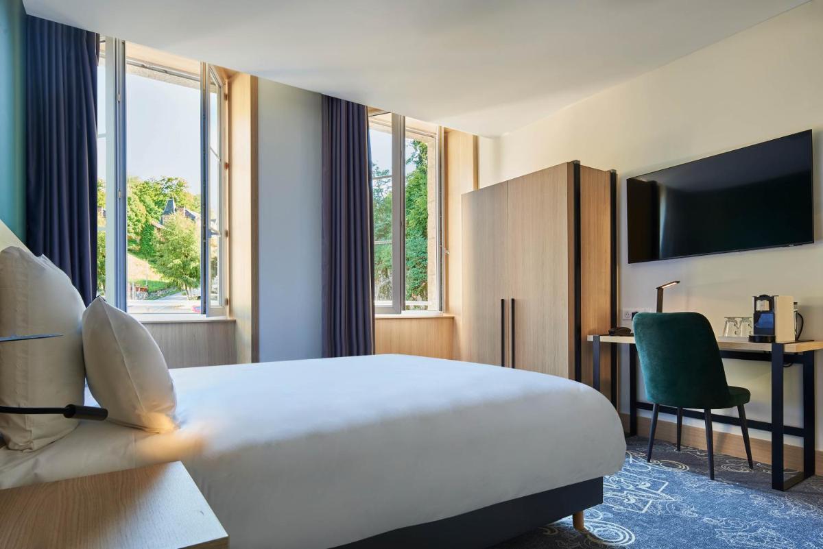 Un ou plusieurs lits dans un hébergement de l'établissement Le Grand Hôtel, The Originals Relais