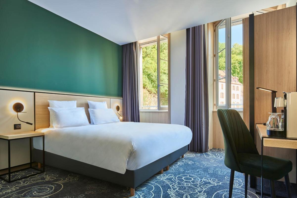 Un ou plusieurs lits dans un hébergement de l'établissement Le Grand Hôtel, The Originals Relais
