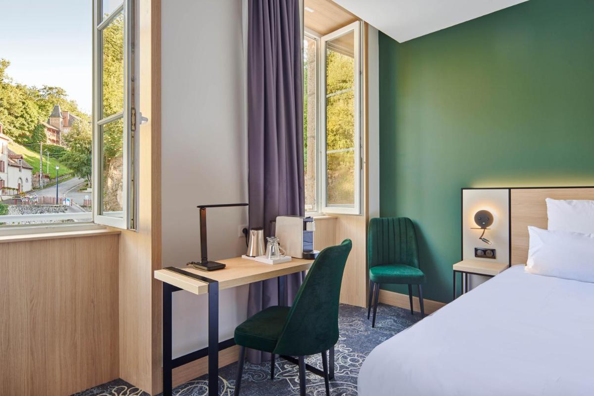 une chambre d'hôtel avec un lit et un bureau et un lit et une fenêtre dans l'établissement Le Grand Hôtel, The Originals Relais, à Évaux-les-Bains
