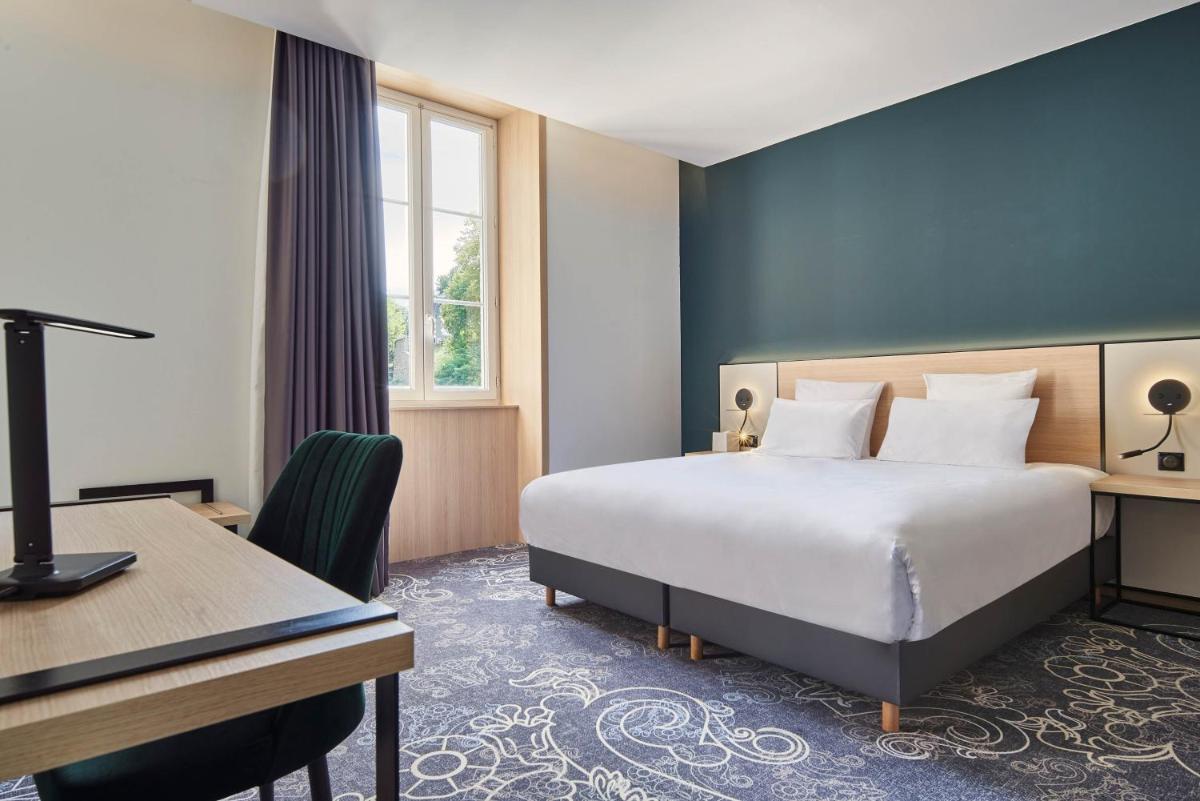 Un ou plusieurs lits dans un hébergement de l'établissement Le Grand Hôtel, The Originals Relais