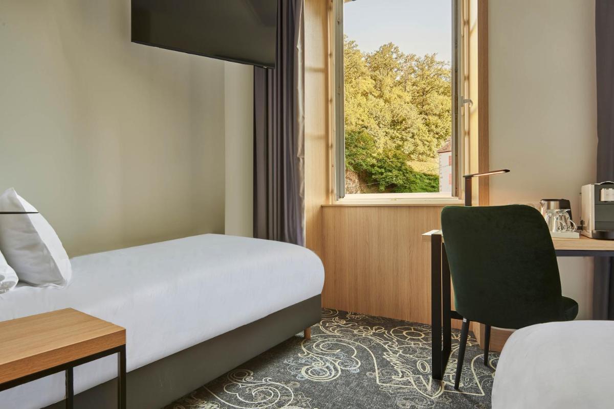 Un ou plusieurs lits dans un hébergement de l'établissement Le Grand Hôtel, The Originals Relais