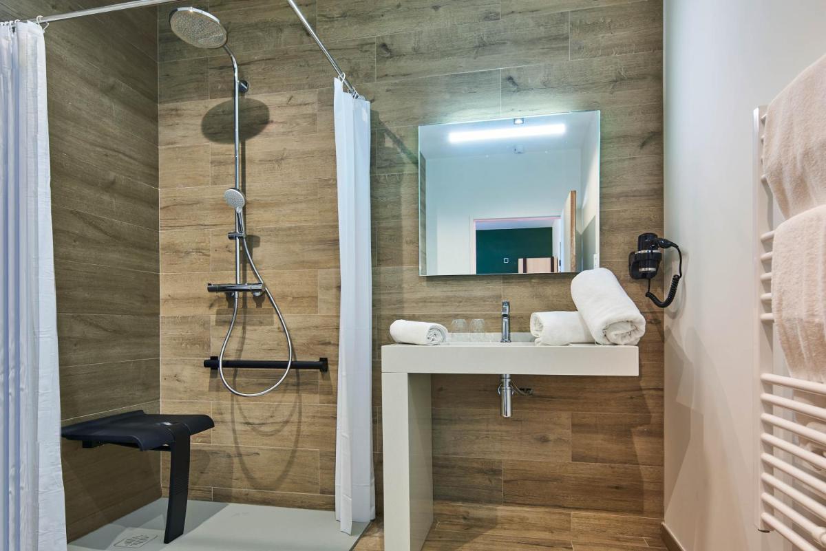 une salle de bain avec lavabo et douche dans l'établissement Le Grand Hôtel, The Originals Relais, à Évaux-les-Bains 33 autres photos