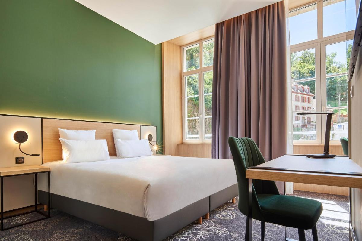 Un ou plusieurs lits dans un hébergement de l'établissement Le Grand Hôtel, The Originals Relais