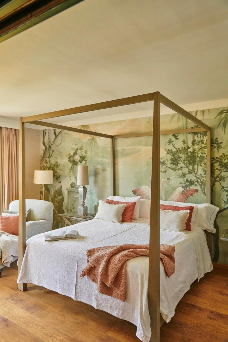 Un dormitorio con una cama con dosel con sábanas y almohadas blancas. en B bou Hotel La Viñuela & Spa, en Viñuela 47 fotos más