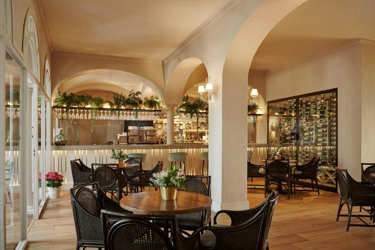 Un restaurante con mesas y sillas y un bar. en B bou Hotel La Viñuela & Spa, en Viñuela