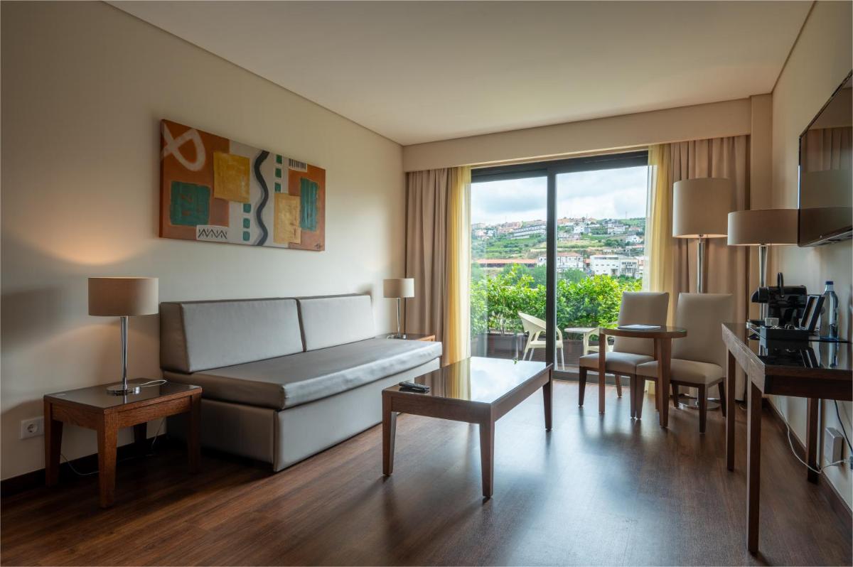 uma sala de estar com um sofá e uma mesa em Vila Gale Collection Douro em Lamego