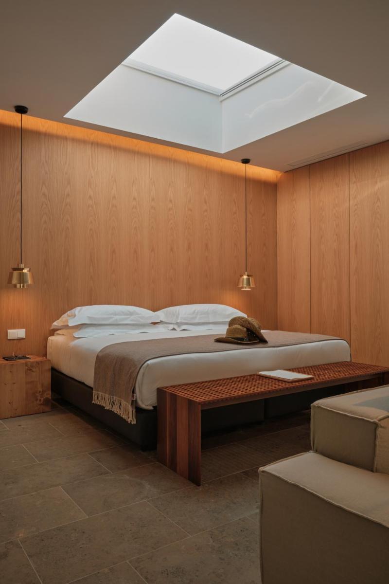 um quarto com uma cama grande e uma clarabóia em L'AND Vineyards - Relais & Châteaux em Montemor-o-Novo