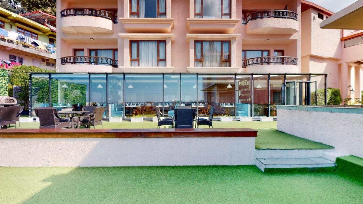 a large building with glass windows and a patio at Radisson Hotel Shimla in Shimla