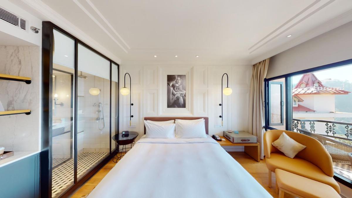 a bedroom with a large bed and a balcony at Radisson Hotel Shimla in Shimla