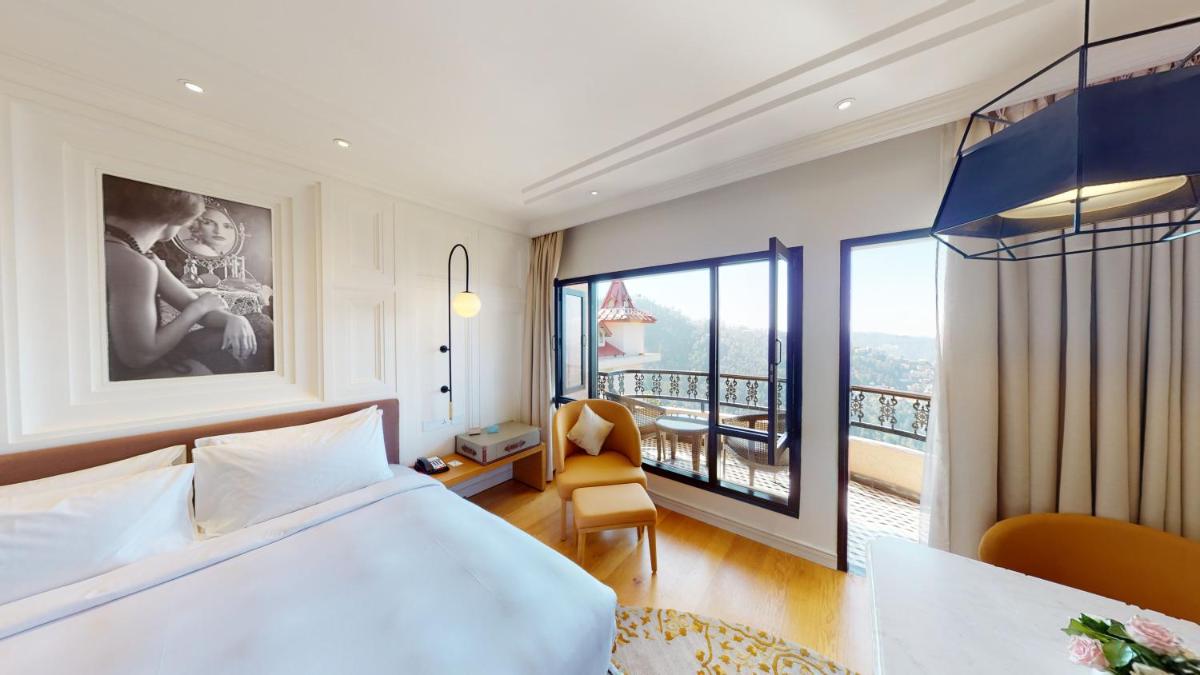 a hotel room with a bed and a balcony at Radisson Hotel Shimla in Shimla