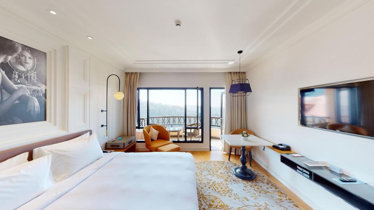 a hotel room with a large bed and a desk at Radisson Hotel Shimla in Shimla