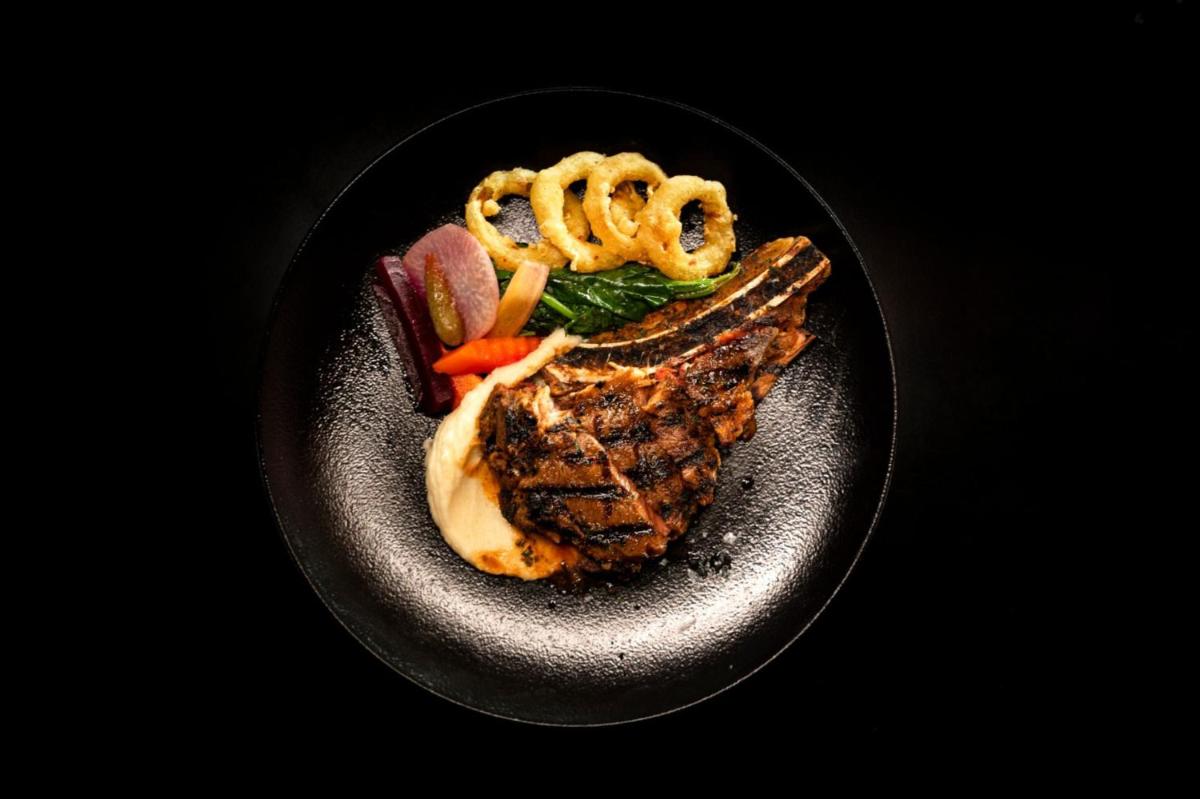 a black plate of food with meat and vegetables at Crowne Plaza Kochi by IHG in Cochin