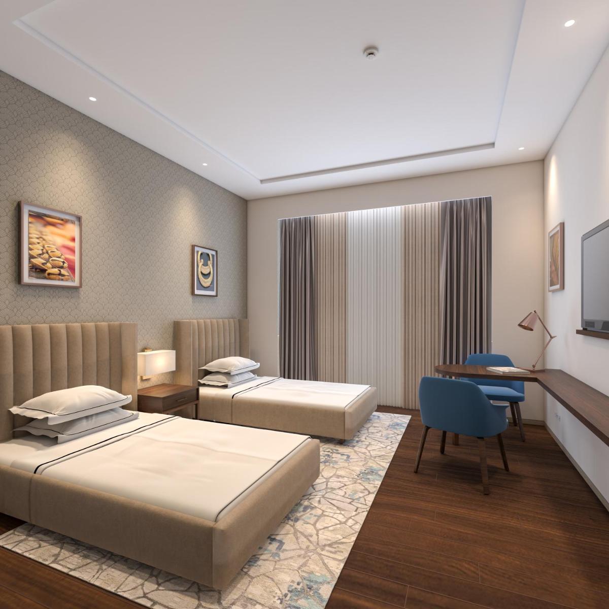 a hotel room with two beds and a desk at Taj Bangalore in Devanahalli-Bangalore