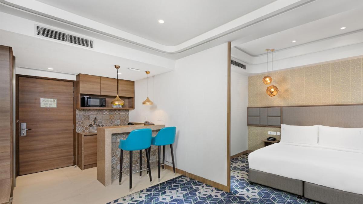a hotel room with a bed and a kitchen at Holiday Inn Gurugram Sector 90 by IHG in Gurgaon