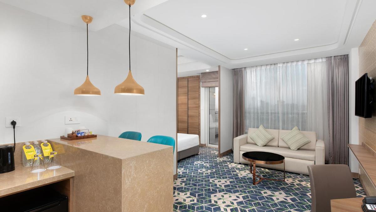 a living room with a kitchen and a living room with a couch at Holiday Inn Gurugram Sector 90 by IHG in Gurgaon
