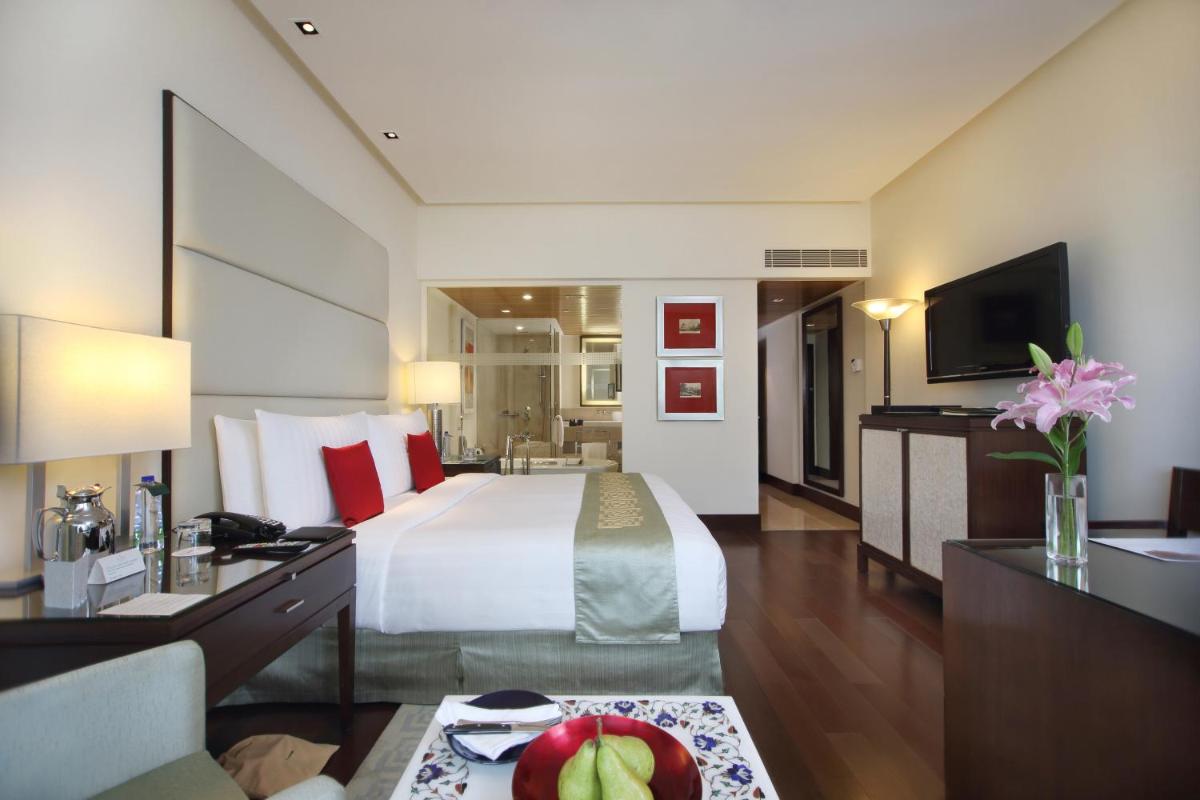 a large hotel room with a bed and a television at The Oberoi Mumbai in Mumbai