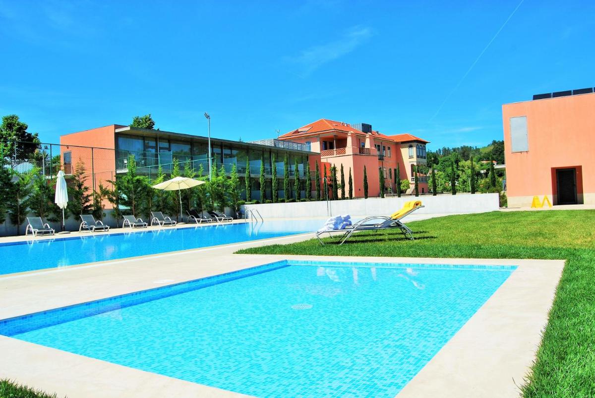 uma piscina em frente a um prédio em Hotel Quinta da Cruz & SPA em Ataíde