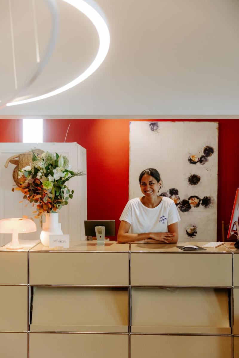 une femme assise à un bureau dans un bureau dans l'établissement Oustau Camarguen Hôtel & Spa, au Grau-du-Roi 84 autres photos