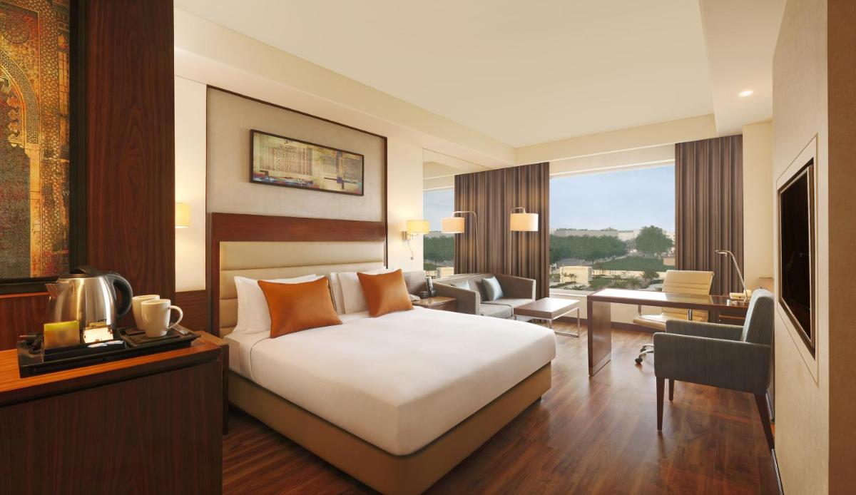 a hotel room with a bed and a living room at DoubleTree by Hilton Agra in Agra
