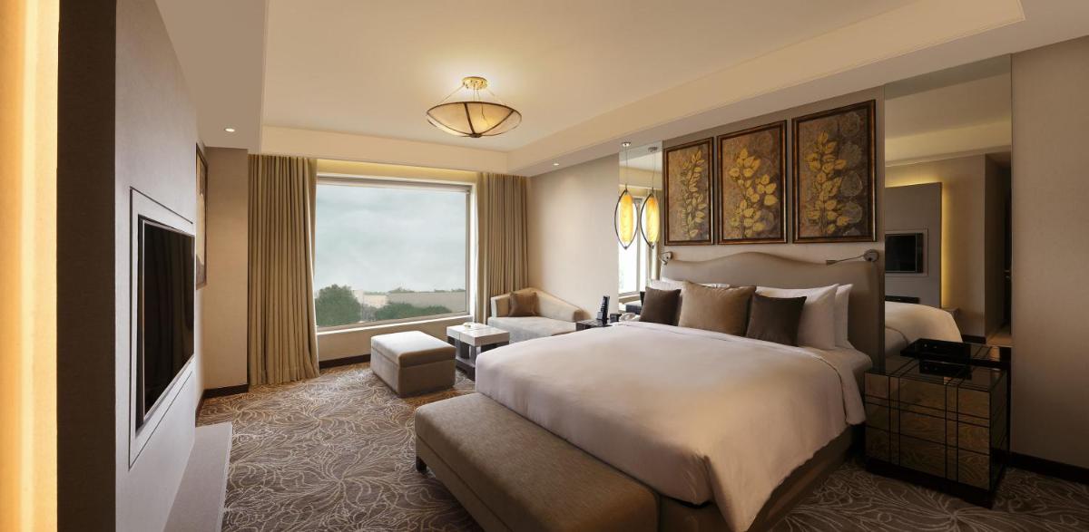 a bedroom with a large bed and a large window at DoubleTree by Hilton Agra in Agra