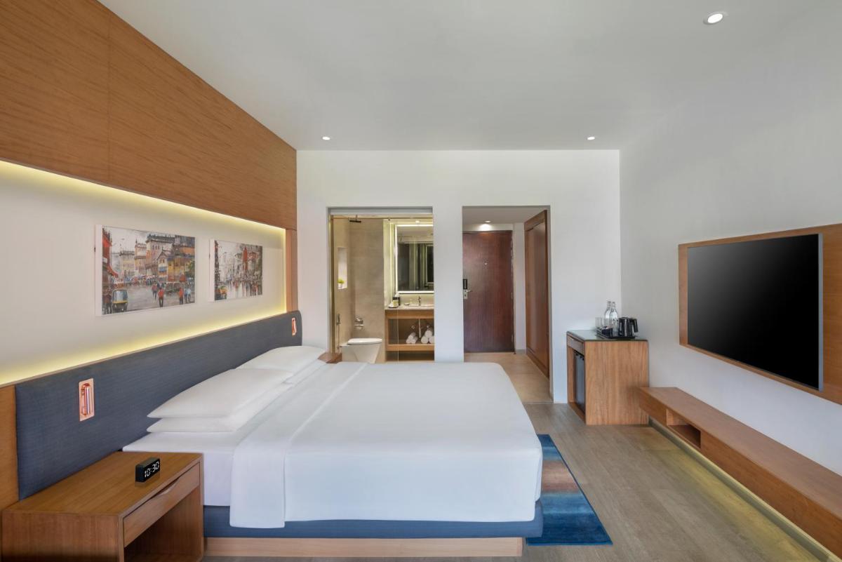 a bedroom with a large bed and a flat screen tv at Hyatt Place Goa Candolim in Candolim a bedroom with a large bed and a flat screen tv at Hyatt Place Goa Candolim in Candolim