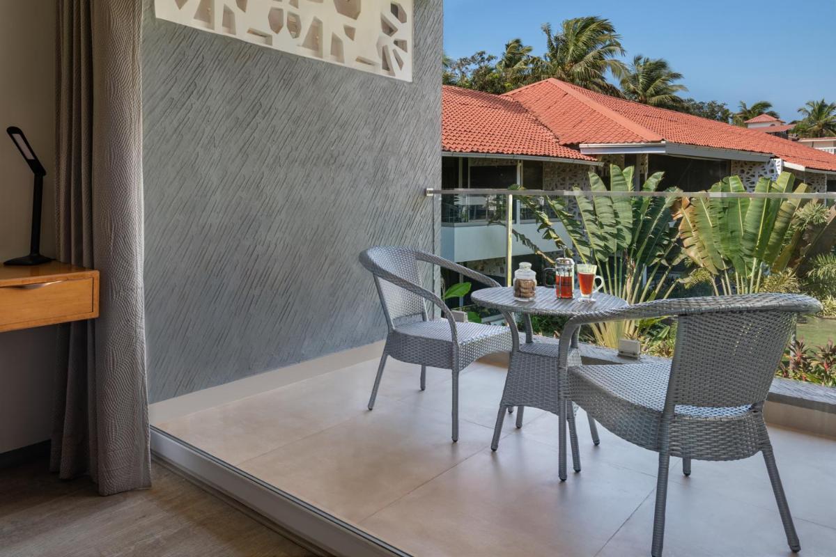 a patio with a table and chairs on a balcony at Hyatt Place Goa Candolim in Candolim a patio with a table and chairs on a balcony at Hyatt Place Goa Candolim in Candolim